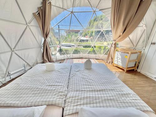 a room with a bed and a large window at ดูดาวแคมป์ริมโขง in Chiang Khan