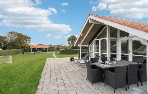 a pavilion with a table and chairs on a lawn at Holiday Home Vandstedet Ix in Nordborg