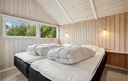 a bedroom with a bed with pillows and a window at Holiday Home Vandstedet Ix in Nordborg