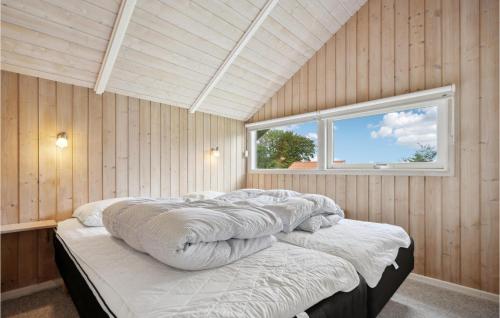 a bedroom with a large bed with a window at Holiday Home Vandstedet Ix in Nordborg