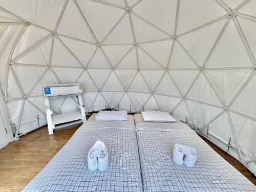 a large tent with two beds and white shoes at ดูดาวแคมป์ริมโขง in Chiang Khan