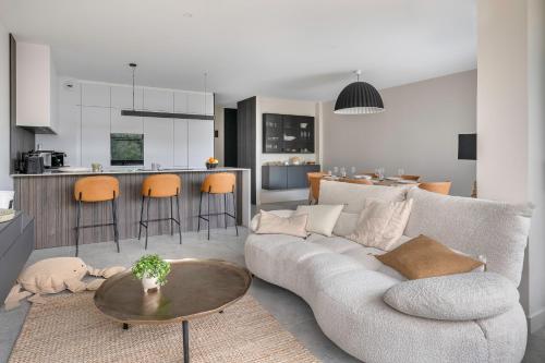 un salon avec un canapé et une table et une cuisine dans l'établissement La Baule plage Benoit- Appartement pour 6, à La Baule