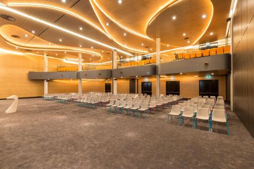 a large auditorium with white chairs and a stage at Park Inn by Radisson Amsterdam City West in Amsterdam