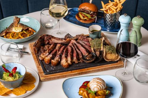 a table with a tray of meat and a sandwich at Radisson Blu Manchester Airport in Hale