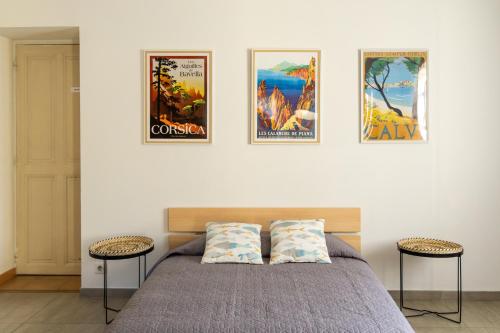 - une chambre avec un lit et quatre affiches sur le mur dans l'établissement Mas Emilie, séjour familial au calme avec piscine, à Châteaurenard