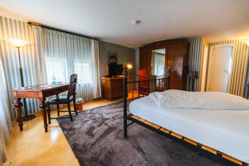 a bedroom with a bed and a desk and a deskablish at Gasthaus Fiester Hannes in Burbach