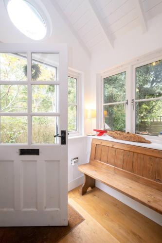 a white room with a bench and two windows at 3 Uplands, Thorpeness - Sleeps 3, Close to Beach, Boating Lake, Thorpeness Golf Club and Country Club - Aldeburgh Coastal Cottages in Thorpeness