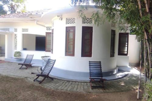 two chairs sitting in front of a house at Crescent N Cocoon in Ambalangoda