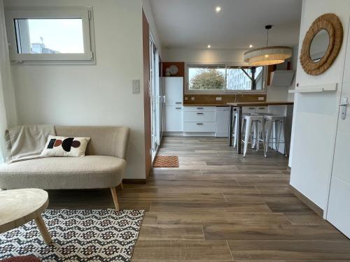 un salon avec un canapé et une cuisine dans l'établissement Petite maison cosy, à Granville