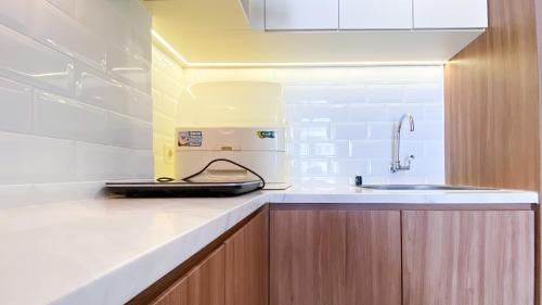 a kitchen with a coffee machine on a counter at Nice and Homey 2BR at Citra Living Apartment By Travelio in Jakarta