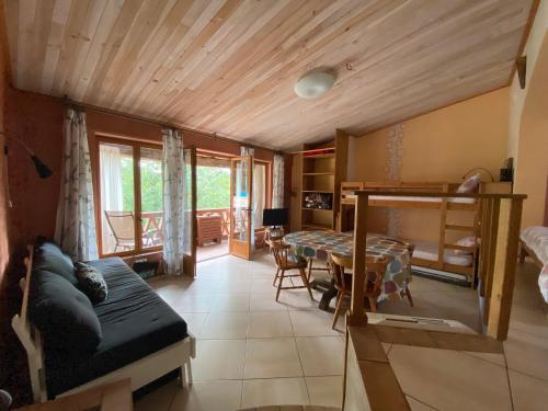 a living room with a bed and a dining room at Can Banal - Camping y Masia Rural in Montagut