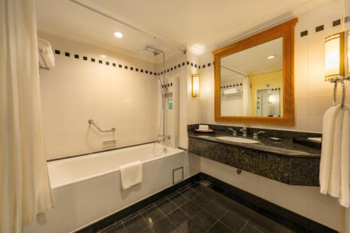 a bathroom with a tub and a sink and a mirror at Saigon Prince Hotel in Ho Chi Minh City