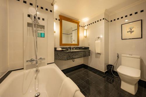 a bathroom with a tub and a toilet and a sink at Saigon Prince Hotel in Ho Chi Minh City