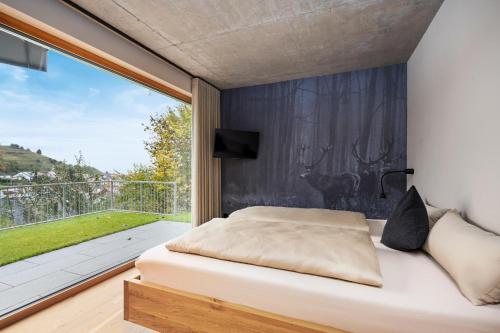 a bedroom with a bed and a large window at Coalhouse Pfalz in Sankt Martin