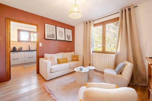 a living room with a couch and a table at Au centre cosy et neuf proche station ski parking terasse in Taninges