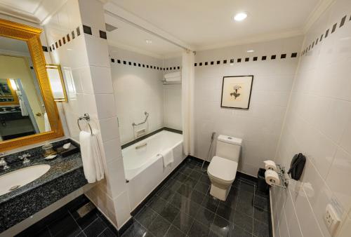 a bathroom with a tub and a toilet and a sink at Saigon Prince Hotel in Ho Chi Minh City