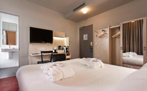 a hotel room with two towels on a bed at Libertel Gare Du Nord Suede in Paris