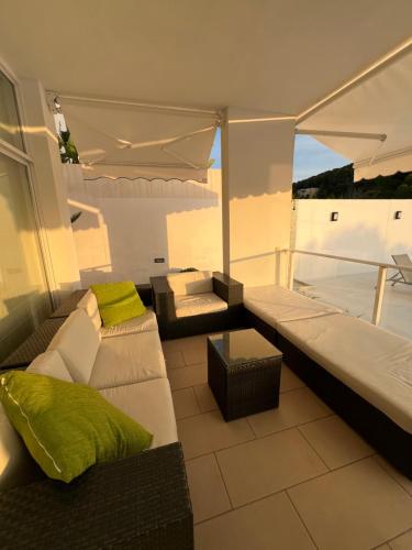 a living room with a couch and a table on a balcony at Chalet en C.Vadella - Piscina privada in Cala Vadella