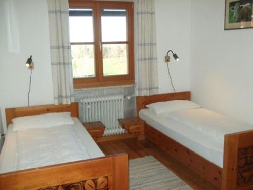 two beds in a room with a window at Agelbauer in Irschenberg