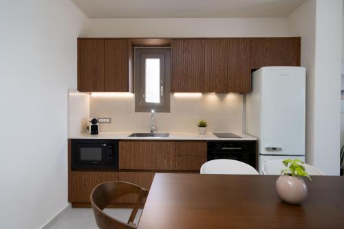 a kitchen with a table and a white refrigerator at Bay View Residences Santorini in Akrotiri
