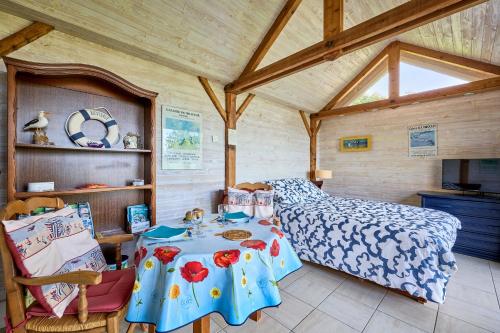 a bedroom with a bed and a table at The Tiny House - maisonette proche de la plage in Manvieux