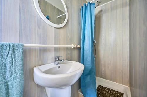 a bathroom with a sink and a mirror at The Tiny House - maisonette proche de la plage in Manvieux