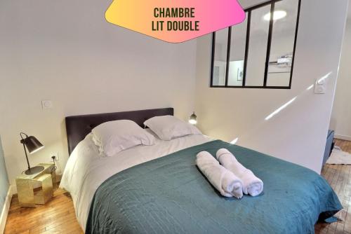 une chambre avec un lit avec deux serviettes dessus dans l'établissement Le logis de Madeleine - ideal couple / solo - coeur de la ville - proche gare, à Troyes