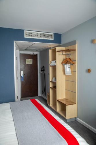 a room with a bed and a red carpet at Holiday Inn Express Royal Docks by IHG in London