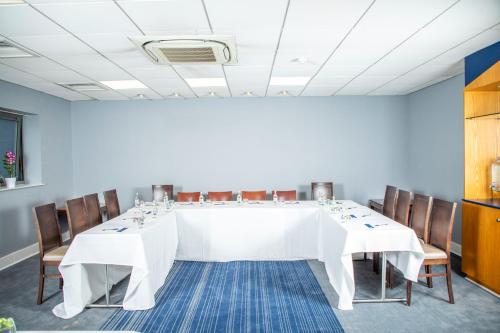 a large white table in a room with chairs at Holiday Inn Express Royal Docks by IHG in London