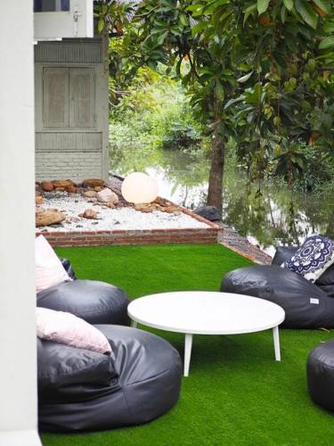 a living area with a table and some bean bags at Lamp U House Amphawa in Amphawa