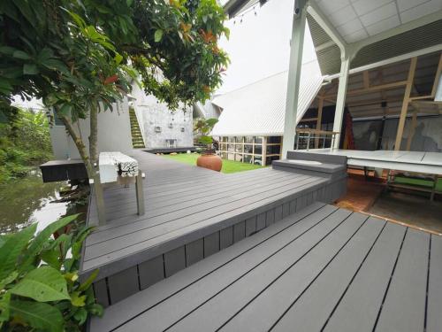 a porch of a house with a wooden deck at Lamp U House Amphawa in Amphawa