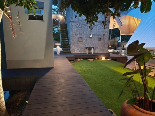 a backyard with a lawn and a fire place at Lamp U House Amphawa in Amphawa
