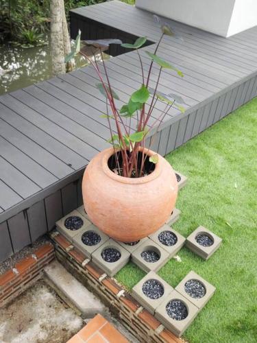 a plant in a pot sitting on the grass at Lamp U House Amphawa in Amphawa