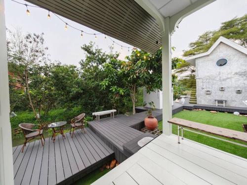a deck with chairs and a table on a house at Lamp U House Amphawa in Amphawa