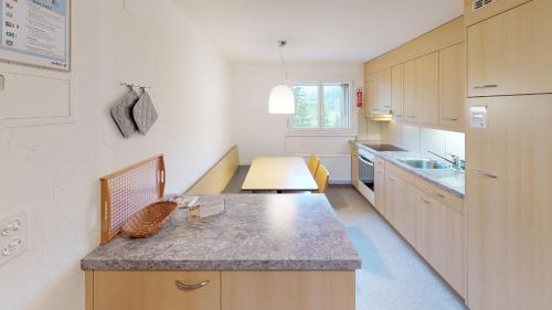a large kitchen with a counter and a sink at Reka-Feriendorf Bergün in Bergün