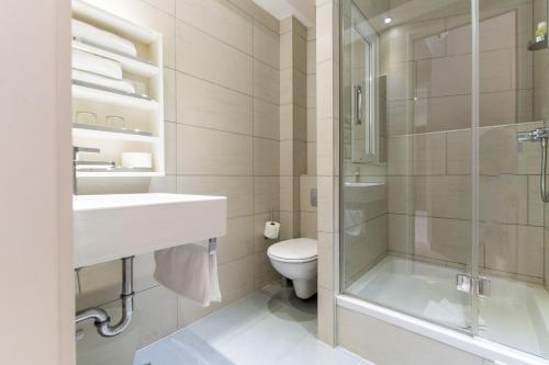 a bathroom with a shower and a toilet and a sink at The Residence Aparthotel in Podstrana