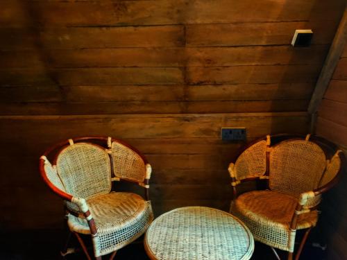 two wicker chairs with a table in a room at Syara villa in Unawatuna