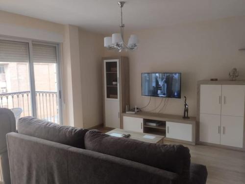 ein Wohnzimmer mit Couch und Flachbildfernseher in der Unterkunft Alquiler Vivienda Completa Don Enrique in Cartagena