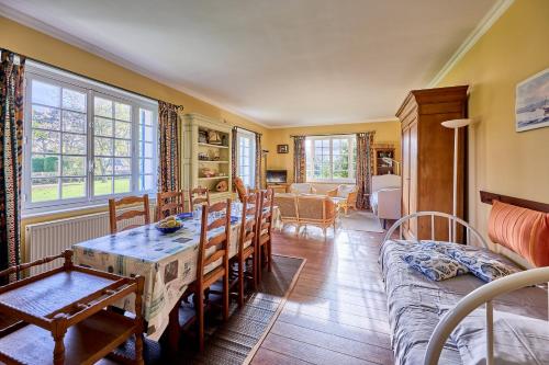 un salon avec une table et un canapé dans l'établissement La Chaumière bleue - Maison plage à 7min à pied, à Manvieux