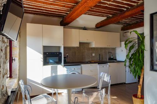 une cuisine avec une table et des chaises dans une pièce dans l'établissement L'Agora - Proche Pharo, Vieux port, Saint-Victor Noailles, à Marseille