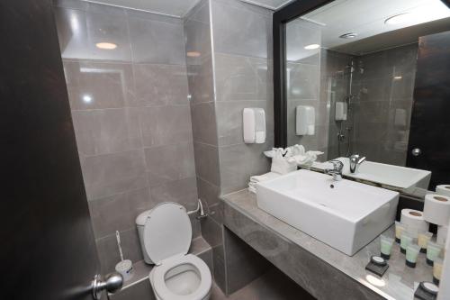 a bathroom with a sink and a toilet and a mirror at G hotel in Eilat