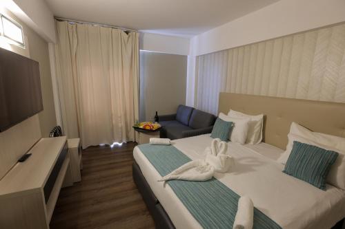 a hotel room with a large bed and a couch at G hotel in Eilat