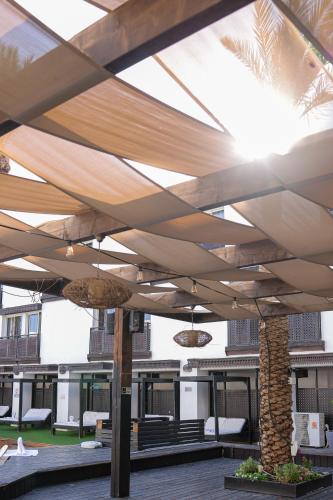 awning over a patio with chairs and a palm tree at G hotel in Eilat