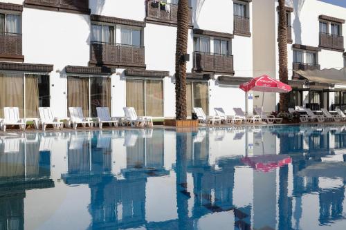 an empty swimming pool with chairs and an umbrella at G hotel in Eilat