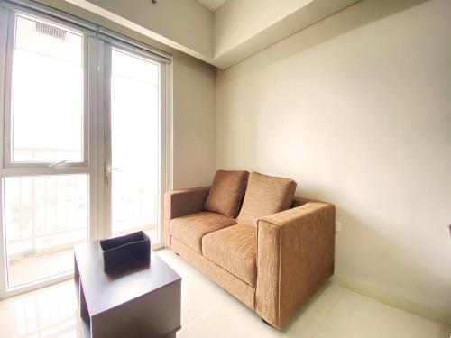a living room with a couch and a table at Fancy 2BR at Skyland City Jatinangor Apartment By Travelio in Sumedang