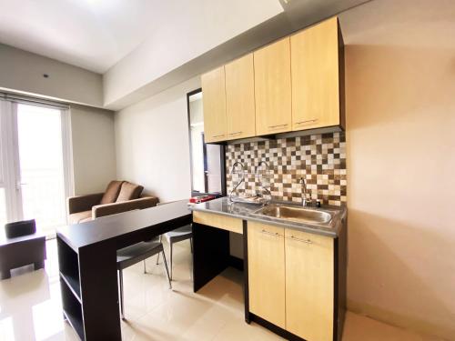 a kitchen with a sink and a counter top at Fancy 2BR at Skyland City Jatinangor Apartment By Travelio in Sumedang