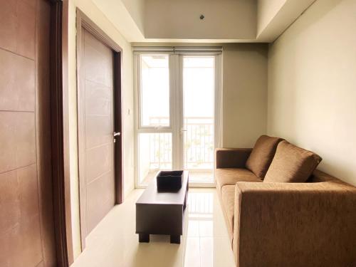 a living room with a couch and a coffee table at Fancy 2BR at Skyland City Jatinangor Apartment By Travelio in Sumedang