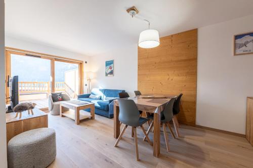 un salon avec une table et un canapé bleu dans l'établissement Les Cristaux Blancs - Station de ski à pied, à Peisey-Nancroix