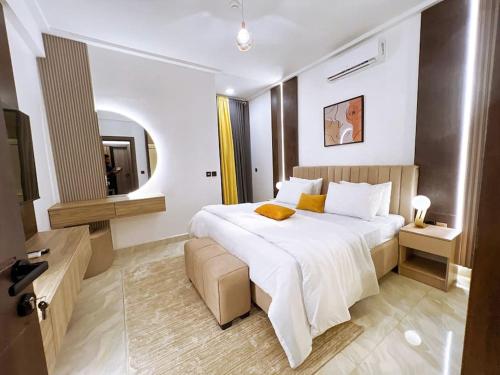 a bedroom with a large white bed and a mirror at a3 nes luxury apartment in Jahi