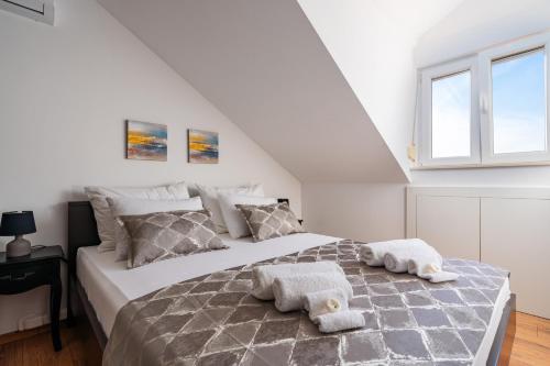 a bedroom with a large bed with towels on it at Nerica Apartment in Zavalatica